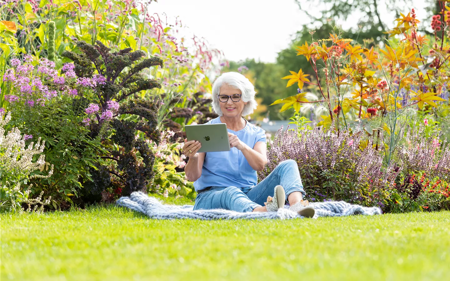 Gartenfreizeit - Frau mit Tablet im Garten